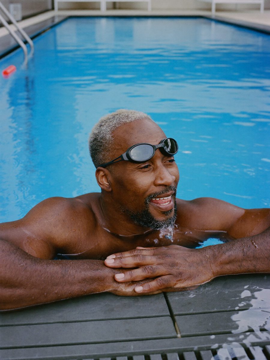 Man resting at the edge of a pool after a swim