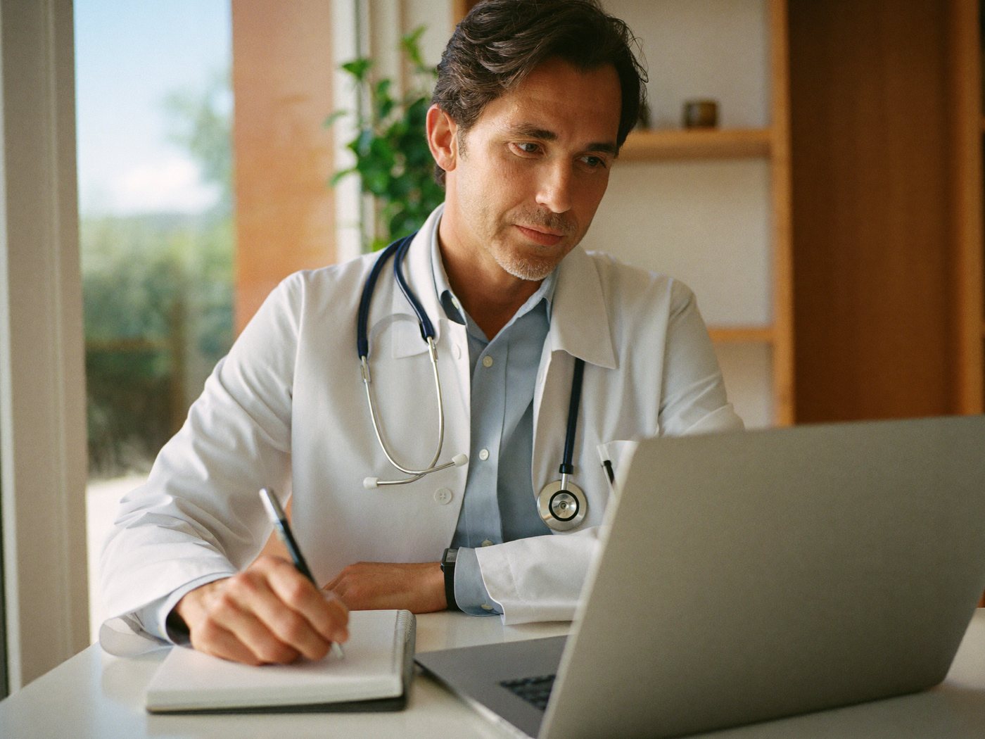 A clinician reviewing a patient's intake at a laptop
